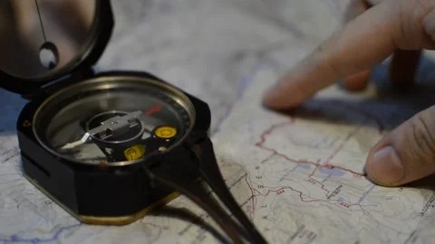 Caucasian man's hand using compass and map for direction. compass direction. Stock-Footage 221321870