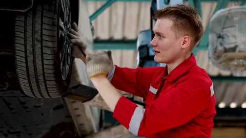 Caucasian mechanic checking efficiency fitting when finish fixing wheels af.. Stock Footage 243720362