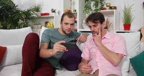 Caucasian Men Laying on the Sofa Viewing a Movie on Mobile Phone Time Relaxation Stock Footage 85499018