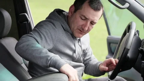 Caucasian men looking something in armrest box his car Stock Footage 76215731