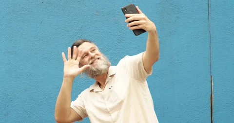 Caucasian middle-aged man makes a video call with a mobile phone Stock Footage 162410964