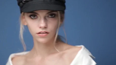 Caucasian model in a black hat posing for a fashion photographer in the studio Stock Footage 81064354