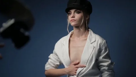 Caucasian model in a black hat posing for a fashion photographer in the studio Video stock 81064362