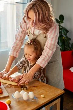 Caucasian mother and daughter prepare flour baked goods on a table in the Stock Photos