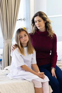 Caucasian mother comforting sick daughter patient sitting together on hospi.. Stock Photos