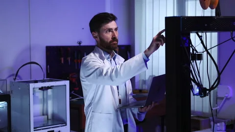 Caucasian office technician worker with computer laptop interacting 3d printer Stock Footage 153745776