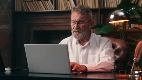 Caucasian old elderly man typing laptop desktop computer working online internet Stock Footage 296193183
