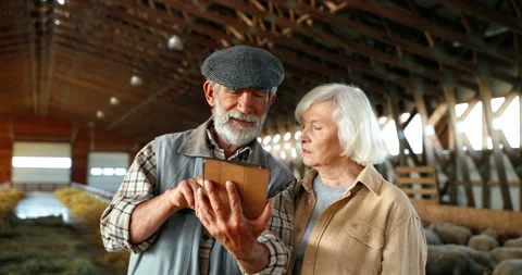 Caucasian old gray-haired man holding tablet device and showing video to woman Stock Footage 139519361