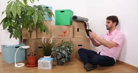 Caucasian Owner Man Using a Computer Tablet Working at Home Design New Apartment Stock Footage 87983892