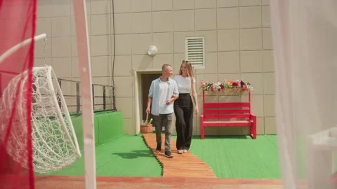 Caucasian pair strolling arm in arm under sunlight and curtains, Intimate couple Stock Footage 329451086
