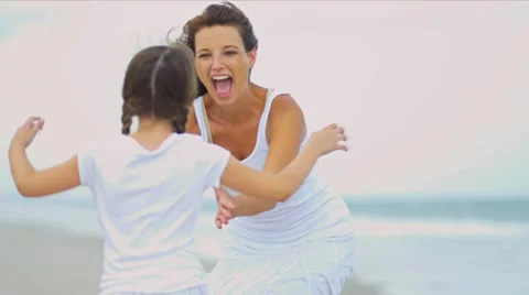 Caucasian parent bonding together young daughter by ocean Stock Footage