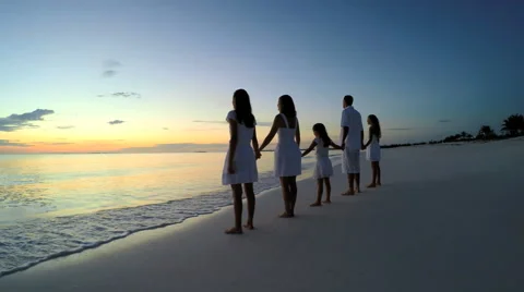 Caucasian parents and female children at sunset on the beach Stock Footage