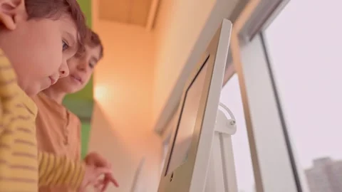 Caucasian pre school and school brothers playing touch screen app on tablet Stock-Footage 246134361