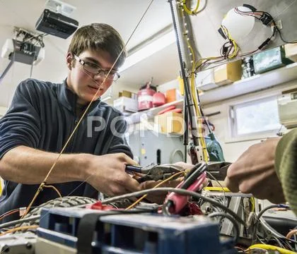 Caucasian Robotics Students Adjusting Machinery