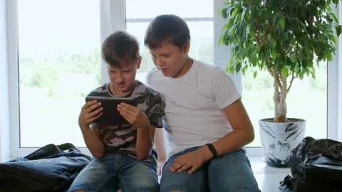 Caucasian schoolboys they use a tablet computer and watch videos Stock Footage 204724077