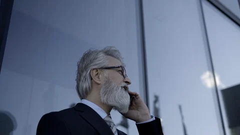 Caucasian senior CEO using a smartphone and smart tablet Stock Footage 104498114