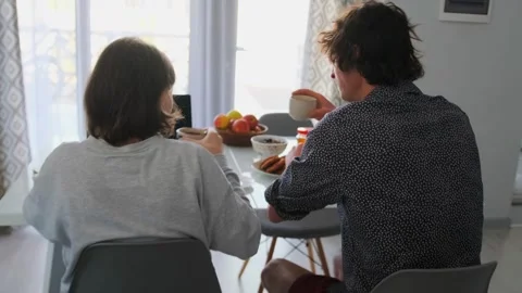 Caucasian Siblings Sharing Coffee And Reviewing Schedule At Table With Laptop Stock Footage 331281343