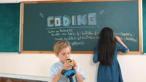 Caucasian smart elementary student fixing machine model at STEM class. Pedagogy. Stockfoto's