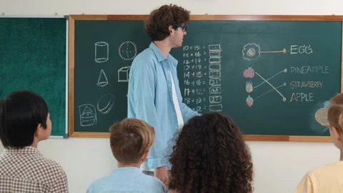 Caucasian smart teacher teach while student standing at blackboard. Pedagogy. Stock Footage 266453861