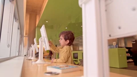 Caucasian smiling pre school boy playing touch screen game on tablet indoor Stock Footage 246134864