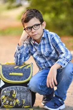 Caucasian student boy with a briefcase sitting on the ground, dreams, sad, cute Stock Photos
