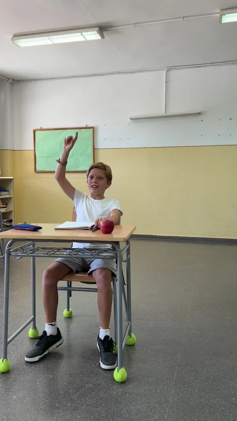 A Caucasian student in the classroom raises his hand to ask Stock Footage 248954085
