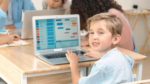 Caucasian student looking at camera while coding prompt in STEM class. Pedagogy. Stock Photos