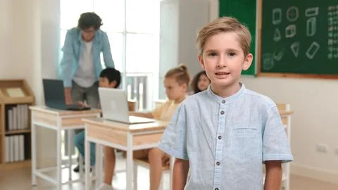 Caucasian student looking at camera while friend studying about code. Pedagogy. Stock Photos