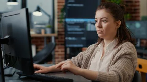 Caucasian system engineer working focused looking at computer screen while 스톡 사진