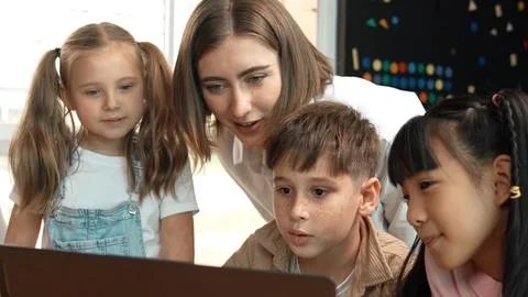 Caucasian teacher checking student answer while learner using laptop. Erudition. Foto stock