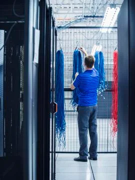 Caucasian technician hanging cables in server room Stock Photos