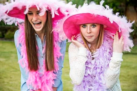 Caucasian teenage girls wearing feather boas and hats Stock Photos