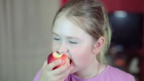 Caucasian white baby eats a nectarine and smiling at the camera. 4K Stock Footage 77316082