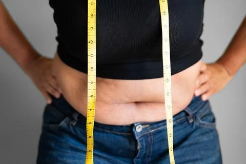 Caucasian Woman With Belly Fat Using Tape Measure Stock Photos