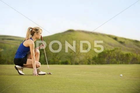 Caucasian Woman Checking Ground On Golf Course