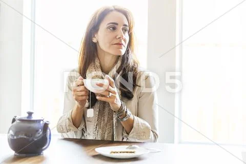 Caucasian Woman Drinking Tea At Table