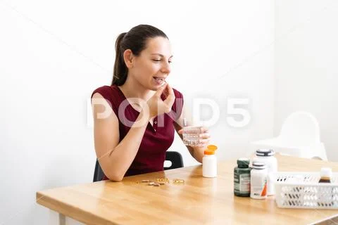 Caucasian woman drinks a lot of pills. Preventive medicine. Food supplements Stock Photos