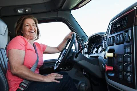 Caucasian woman driver in the cab of a  commercial truck. Stock Photos
