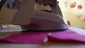 Caucasian woman is ironing pink strips of fabric with white iron HD Footage