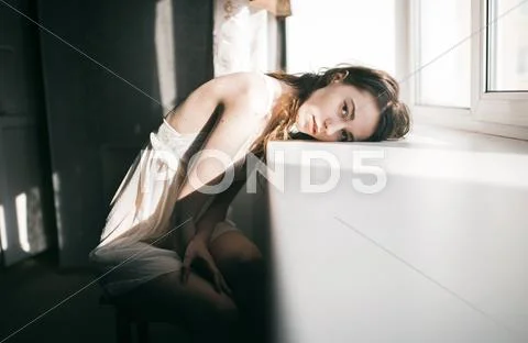Caucasian woman leaning on windowsill Stock Photos