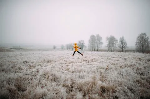 Caucasian woman leaping in snowy field Stock Photos