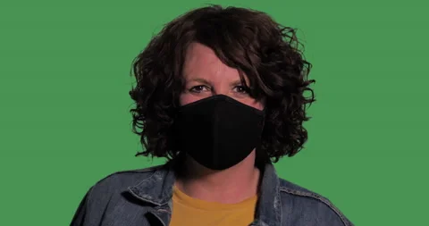 Caucasian woman models mask in front of green screen. Stock Footage