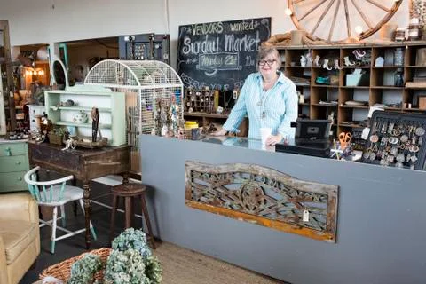 Caucasian woman owner of an antique store standing near the cash register Stock Photos