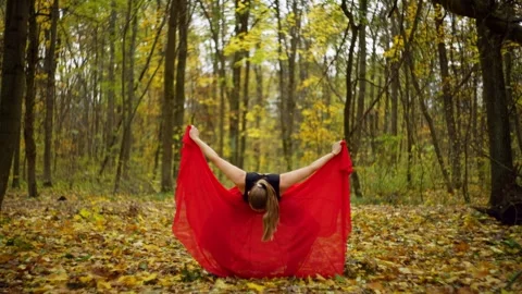 A Caucasian woman performs elements from a folk dance in the middle of forest. Stock Footage 255794841