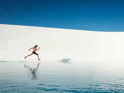 Caucasian woman running on water surface Stock Photos