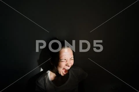 Caucasian woman screaming in sunlight. Black shadows. Mental health Stock Photos