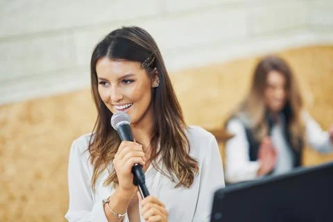 Caucasian woman singing into microphone in studio Stock Photos