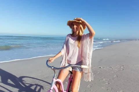 Caucasian woman spending time seaside and riding a bike Stock Photos