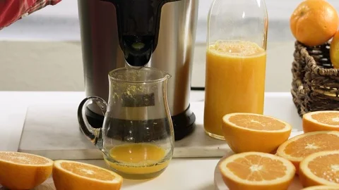 Caucasian woman squeezing oranges using electric juicer, accelerated videoi Stock Footage 125543336