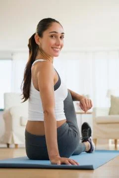Caucasian woman stretching on exercise mat Stock Photos
